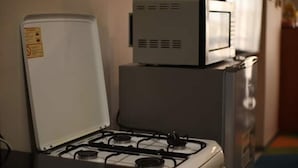 Una cocina equipada con estufa, microondas y refrigerador.