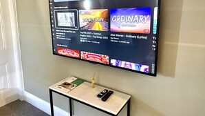 Televisor de pantalla plana montado en la pared que muestra un canal de YouTube con contenido musical.