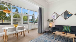 Una sala de estar moderna con comedor, ventanas amplias y vistas al exterior.