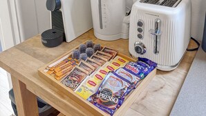 A kitchen counter with a coffee machine, a kettle, a toaster, and a tray of coffee pods. - Cute 1 bedroom with private courtyard garden (North Sydney)