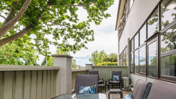 An outdoor patio with a glass table, two chairs, and a sofa. - Sun Drenched Ground Floor Studio with Patio (North Sydney)