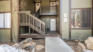 A multi-level wooden staircase leading to a door marked 169 and 171.