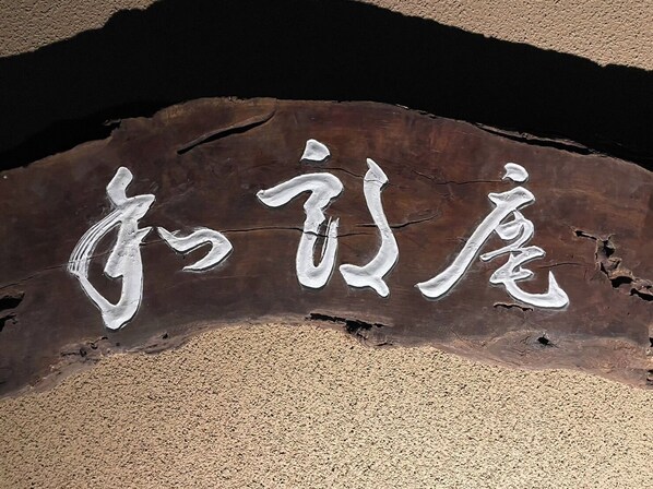 A wooden sign with carved Chinese characters. - Warouan (Nikko)