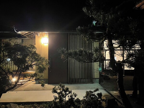 A modern building with a sloped roof, a visible entrance, and a small porch area. - Warouan (Nikko)