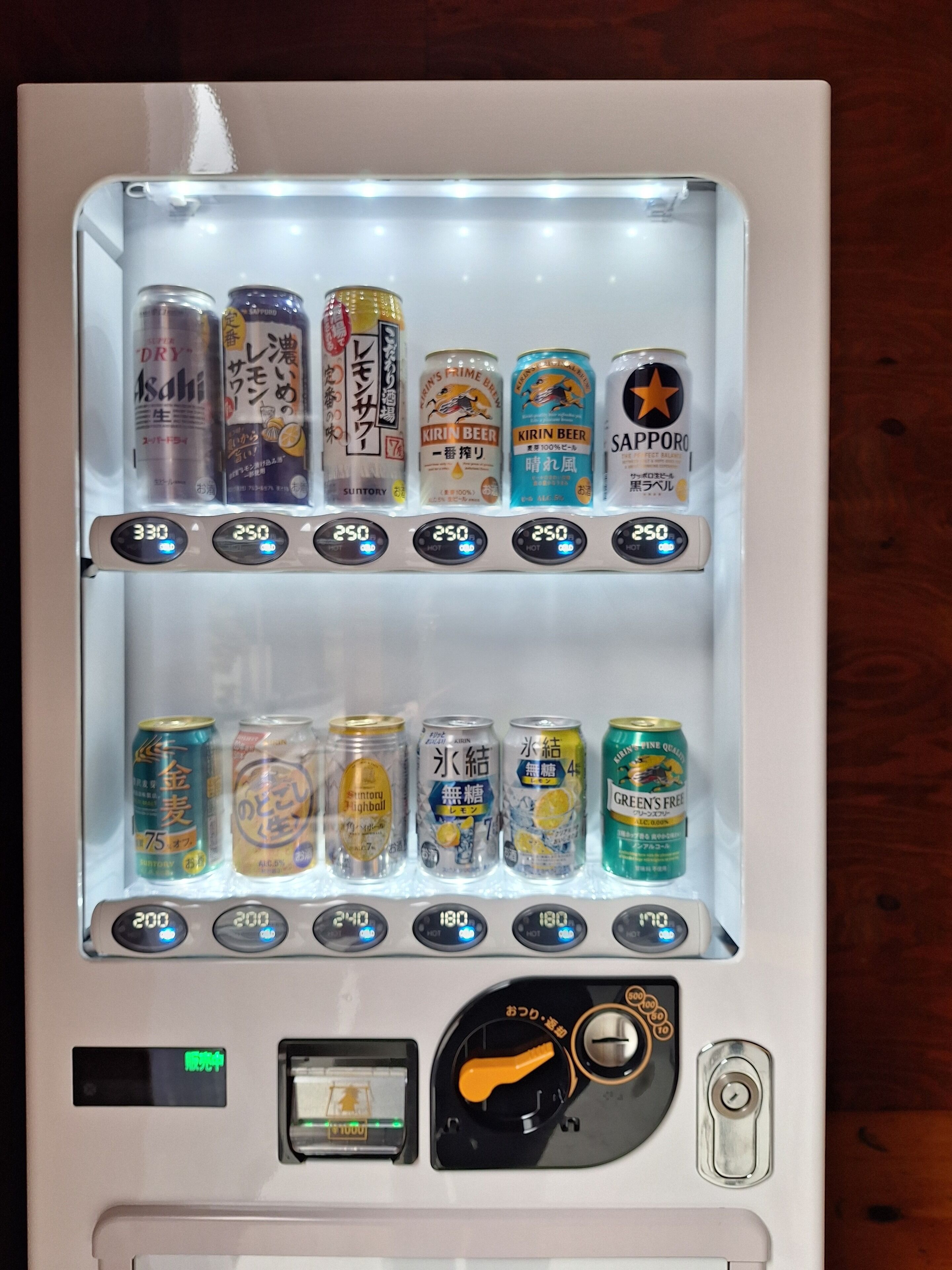 A vending machine with various beverages and snacks, including Kirin beer and Sapporo.
