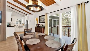 Un comedor con una mesa de madera, sillas y posavasos de mimbre.