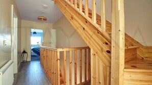 A wooden staircase with a railing, leading to an upper floor. - Shepherds Rest - Four bedroom home (County Kerry)