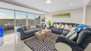 A modern living room with a grey sectional sofa, a coffee table, and a patterned rug.