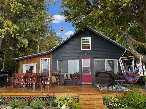 Una casa con terraza, muebles de exterior y una hamaca.