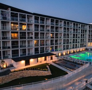 Een meerhoog hotel met een zwembad en een terras.