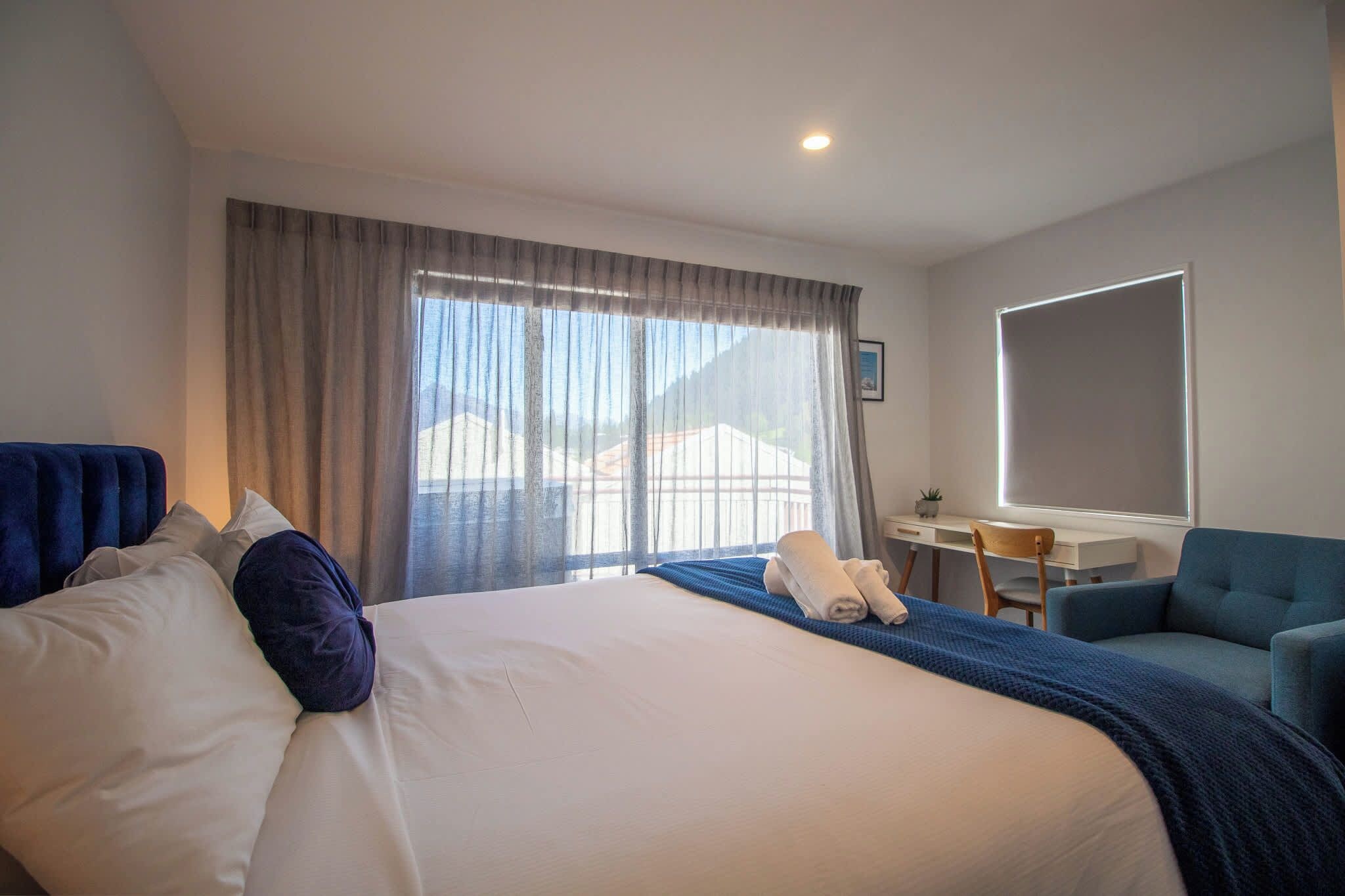 Une chambre d’hôtel avec un grand lit, un bureau et une chaise.