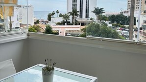 A balcony with a view of a tall building labeled "RIU" and a palm tree. - Erisa 1, 47 - Studio with Terrace, Pool, Parking, 2nd line beach (Torremolinos)