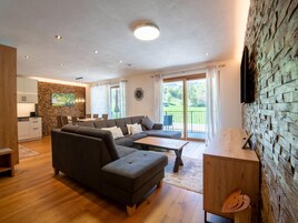 Ein modernes Wohnzimmer mit Ecksofa, Essbereich und Küche.