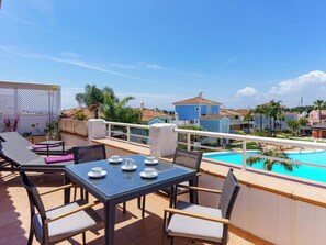 Eine Dachterrasse mit Pool, Liegestühlen und einem Tisch mit Tassen und Untertassen.