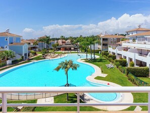 Ein Resort mit großem Schwimmbecken, mehreren Gebäuden und Palmen.