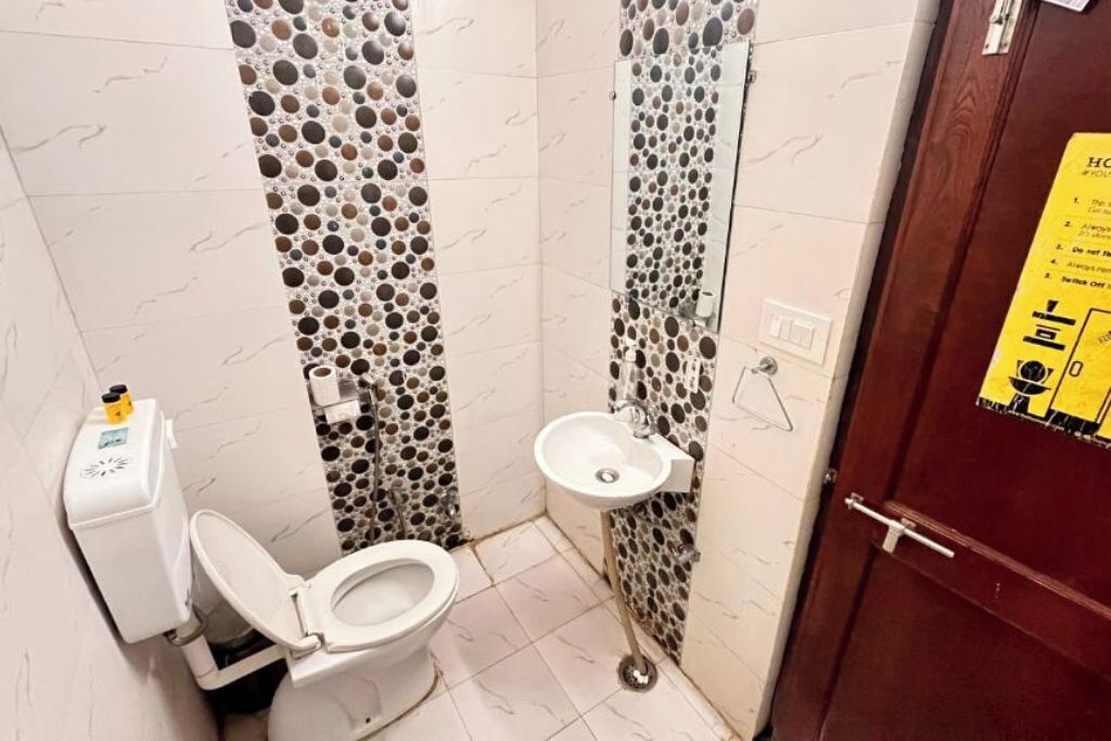A small bathroom with a toilet, sink, and decorative wall panels.