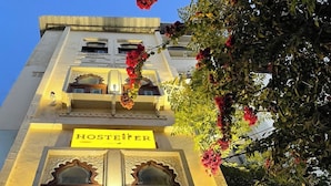 A building with a sign reading "HOSTELER" and ornate architectural details. - The Hosteller Udaipur (Udaipur)