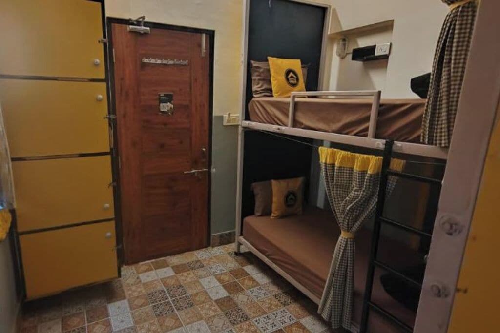 Ein Schlafsaalzimmer mit Etagenbetten, einer Holztür und einem Fliesenboden.