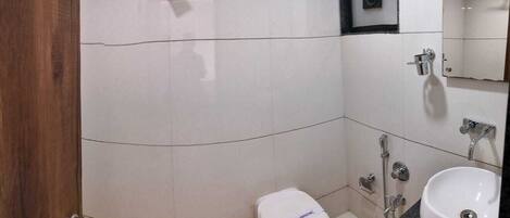 Un baño con inodoro, lavabo y ducha.