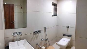 Habitación ejecutiva | Baño | Ducha, artículos de higiene personal gratuitos, zapatillas y toallas