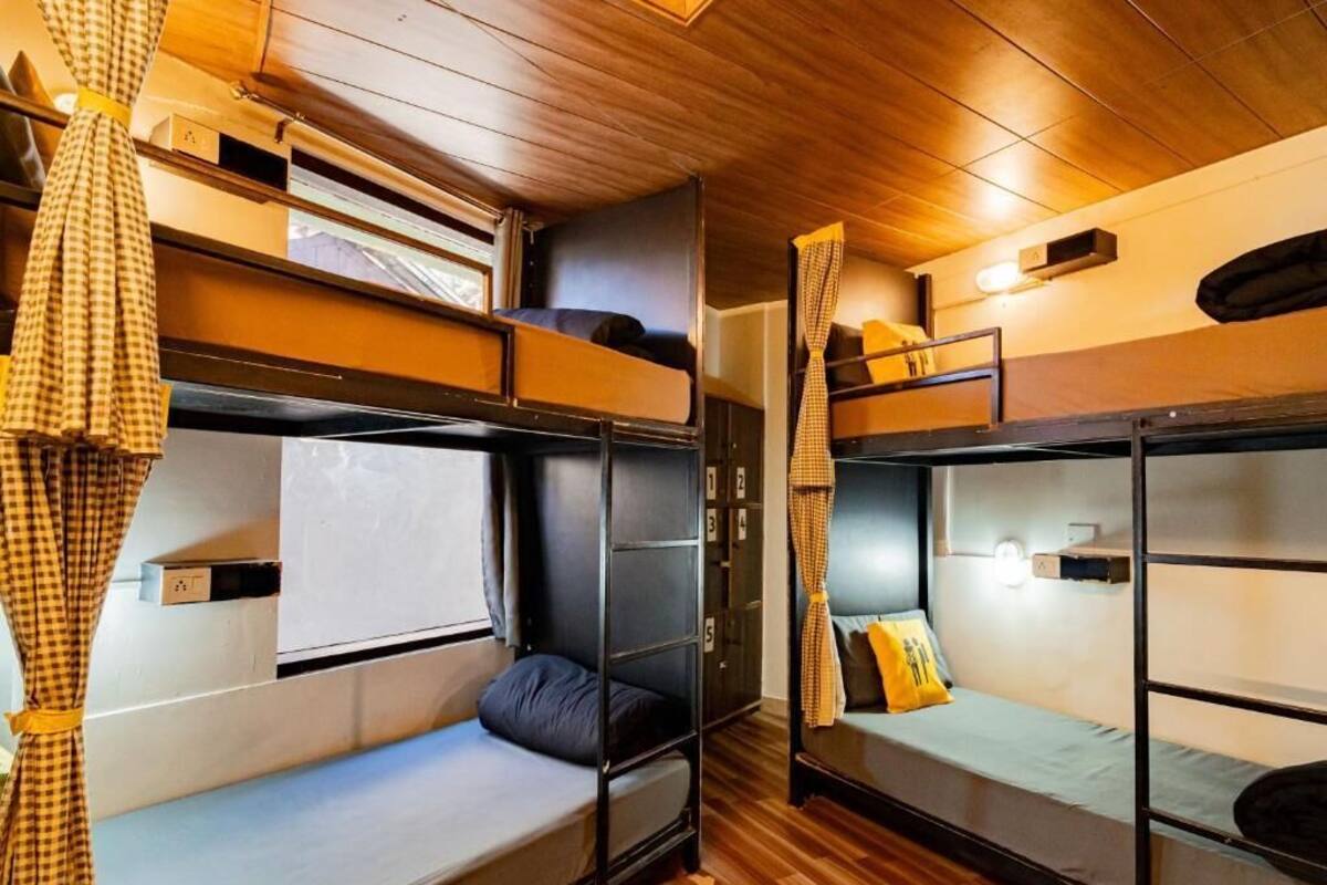 Un compartiment de train avec deux lits superposés, un plancher en bois et une fenêtre.