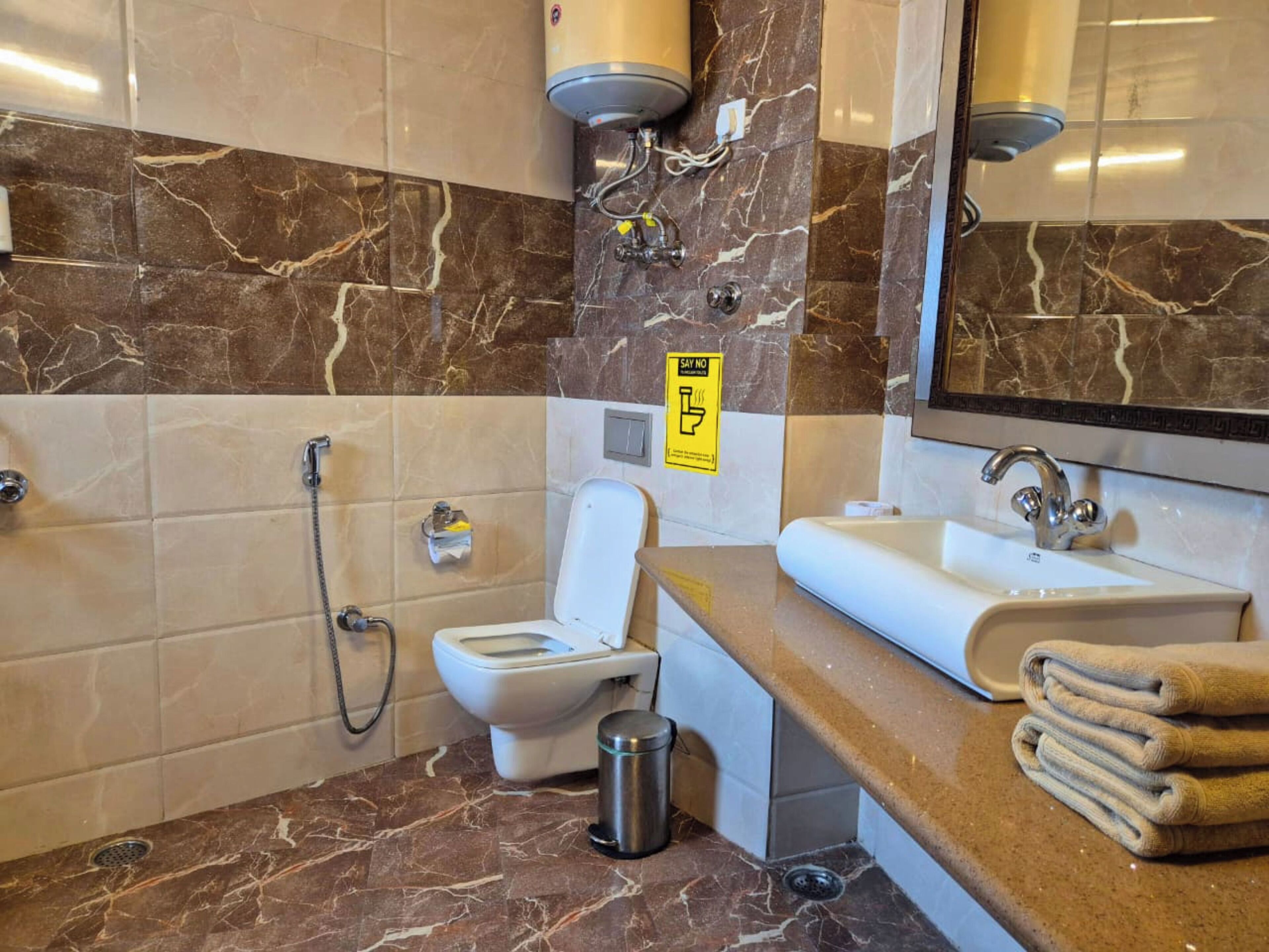 Un baño con inodoro, bidé, lavamanos y espejo.