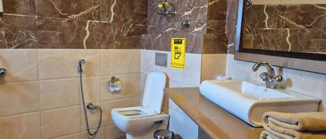 Un baño con inodoro, bidé, lavamanos y espejo.