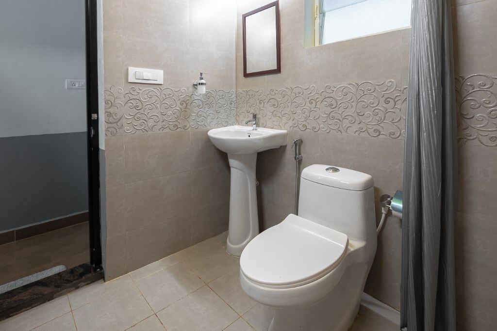 A bathroom with a toilet, sink, and shower curtain.