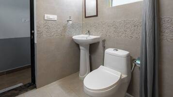 A bathroom with a toilet, sink, and shower curtain.