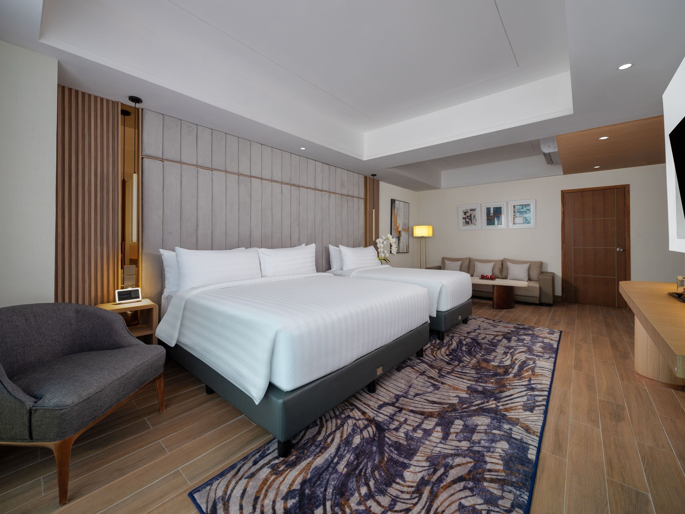 Una habitación de hotel moderna con una cama grande, un sofá, un escritorio y una televisión.
