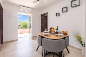A dining area with a table set for two, a bottle of wine, and a bowl of fruit. - Harmony House Vito With Lovely Terrace, Lopar, Croatia (Lopar)