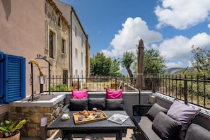 Un balcone con sedute all'aperto, un vassoio con cibo e una rivista.