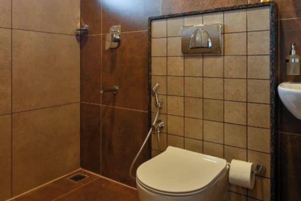 A bathroom with a toilet, a shower, and a sink.