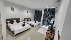 A hotel room with two beds, a desk, a chair, and a window with curtains. - DA Airport Hotel (Sa Khu)