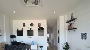 A spacious living area with a black marble reception desk, a black sofa, and a potted plant.