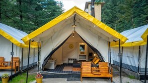 Eine Zelthütte mit einer zentralen Wohnbereitschaft, Holzmöbeln und einer Uhr an der Wand.