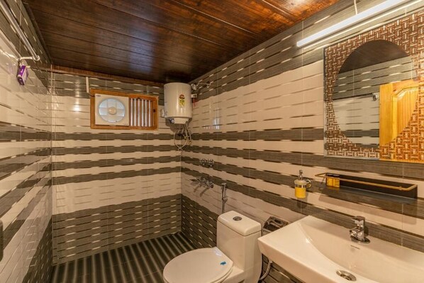 Un baño con paredes de baldosas a rayas, un inodoro blanco, un lavamanos, un espejo y una ducha.
