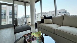 Een moderne woonkamer met een bank, fauteuil en salontafel met boeken.