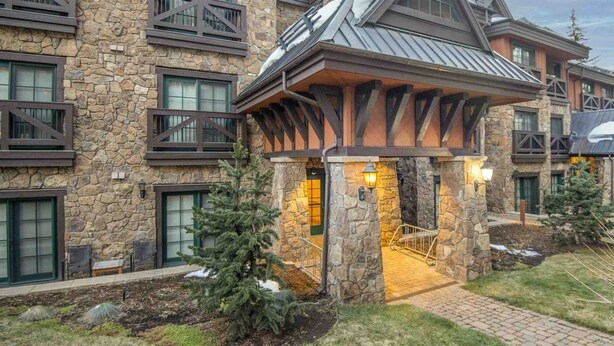 Ein Steinhaus mit überdachter Veranda und einer Treppe, die hinauf führt.