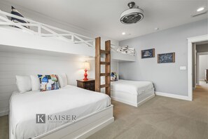 Ein Hotelzimmer mit Etagenbett, Schreibtisch mit Lampe und einer kleinen Sitzecke.