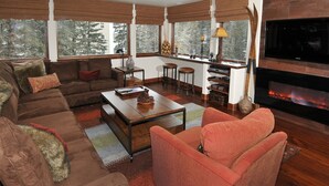 Una sala de estar con sofá, sillones, una mesa de centro y una chimenea.