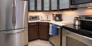 Enjoy cooking in this well-equipped kitchen with a refrigerator, oven, microwave, coffee maker, and kettle.