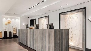 A reception desk with a modern design, featuring a marble-like surface and framed artwork on the walls. - Luxury 3 Bedroom Residence at The Four Seasons in Vail Village (Vail)