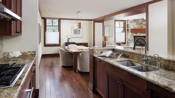 A modern kitchen with granite countertops, a built-in stove, and a stone fireplace. - Luxury 1 Bedroom Residence at The Four Seasons, Vail (Vail)