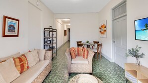 Una sala de estar con sofá, sillón y un comedor con sillas y mesa.