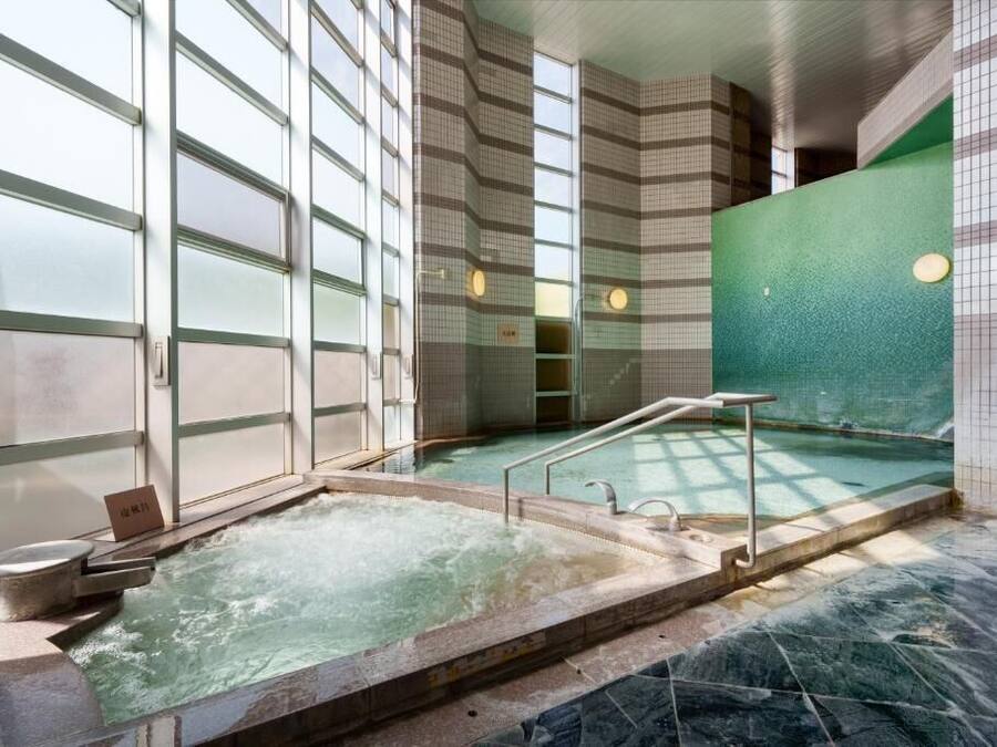 A spa area with a hot tub, a small pool, and a glass-enclosed shower area.