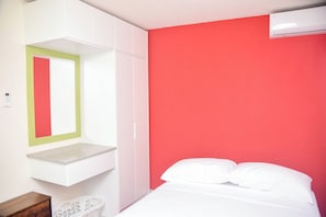Cozy retreat with a red accent wall, a comfortable bed, and a stylish wardrobe.
