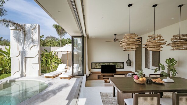 A modern outdoor living area with a pool, lounge chairs, a dining table, and a TV. - Villa Bōld 01 At Bōld - Luxury Villas (Pecatu)