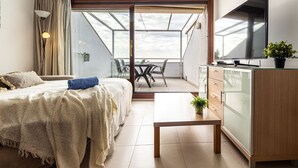 Een moderne slaapkamer met een bed, nachtkastje en een televisie.