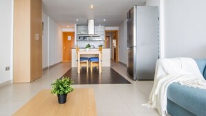Un appartement moderne comprenant une cuisine, un coin repas et un salon avec un canapé et une plante.